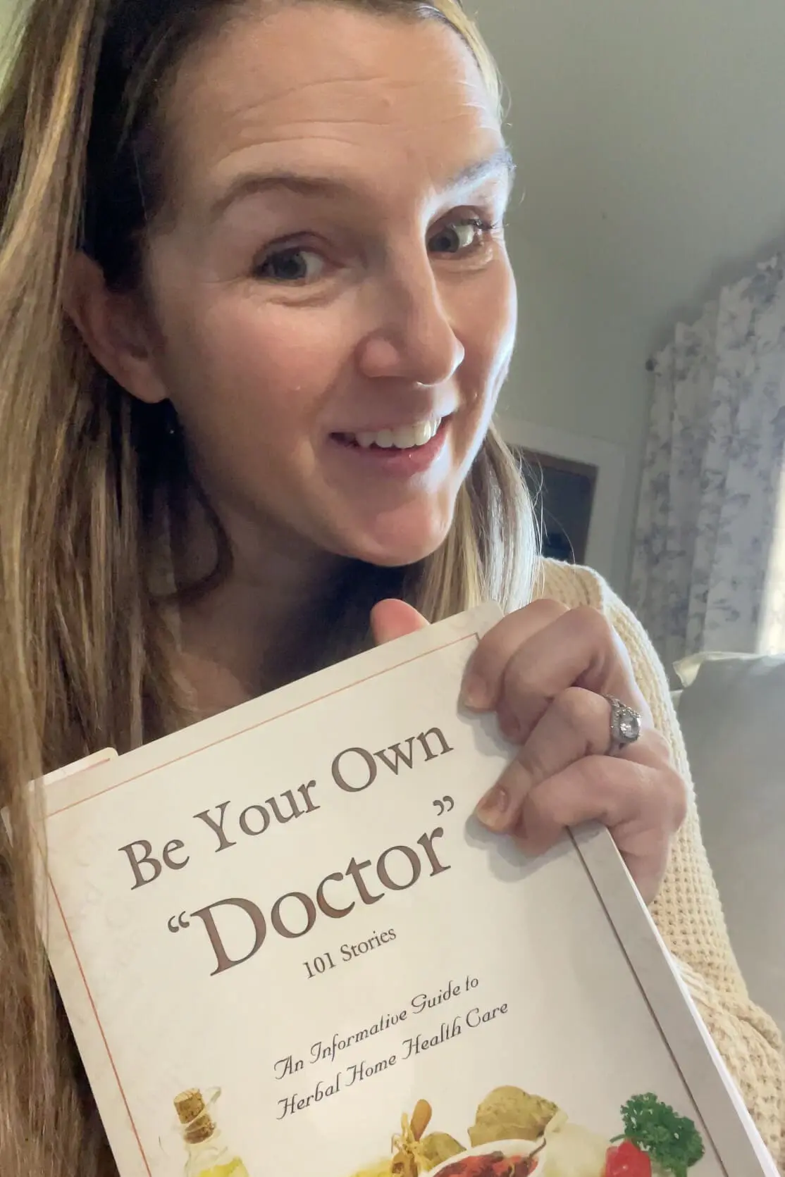 Smiling woman holding a copy of 'Be Your Own Doctor,' a trusted herbal home remedy guidebook.